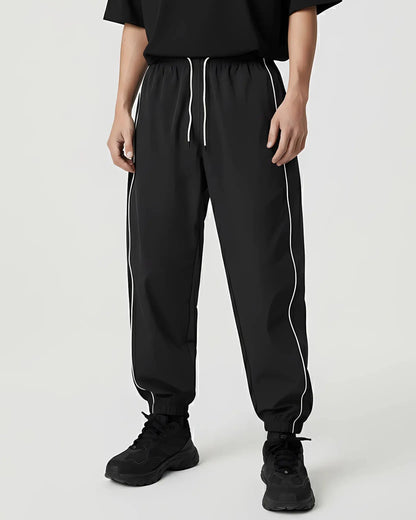Reflective Nightflow Hose in Schwarz, lässig getragen, ideal für Techno und Rave.