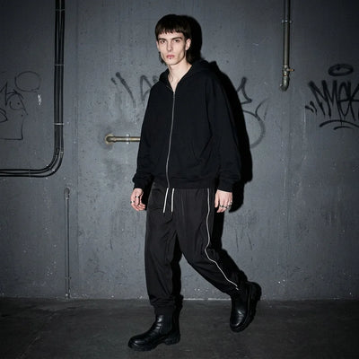 Laufendes Model in Reflective Nightflow Hose, schwarz, perfekt für Rave-Partys.